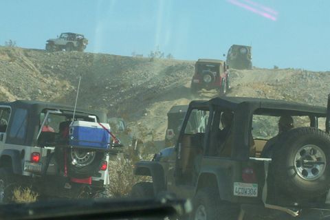 1995 Ford Bronco - A convoy of Jeeps navigates a challenging off-road terrain on a sunny day.