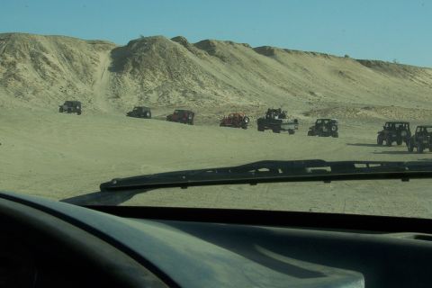 1995 Ford Bronco - A convoy of off-road vehicles navigates a sandy desert terrain.