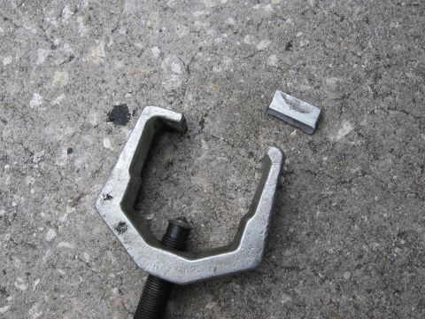 1974 Ford F-100 - A ball joint separator tool lies on concrete next to a small metal fragment.
