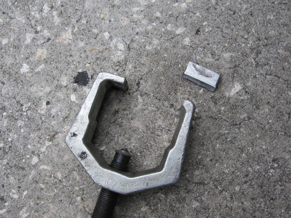 Ball joint separator tool and a broken piece on concrete