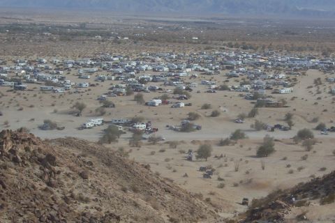 1995 Ford Bronco - A large group of vehicles and RVs are gathered in a desert area.