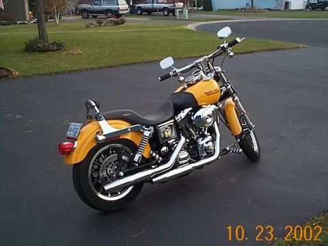 1998 Ford Crown Victoria - A yellow motorcycle is parked on an asphalt surface with a residential background.