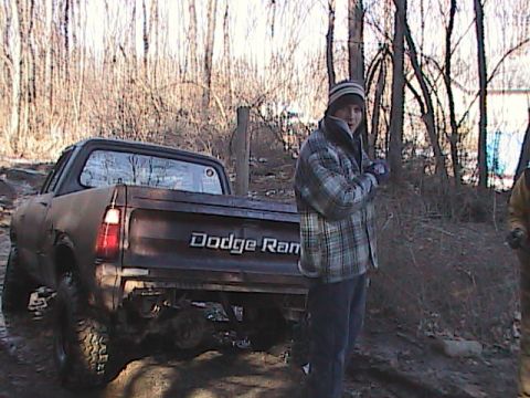 1980 Dodge Magnum - A person stands next to a Dodge Ram pickup truck in a muddy, wooded area.