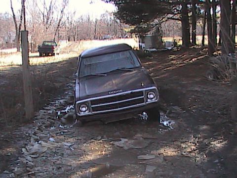1980 Dodge Magnum - A brown Dodge Ramcharger is stuck in a muddy, debris-strewn area with trees in the background.