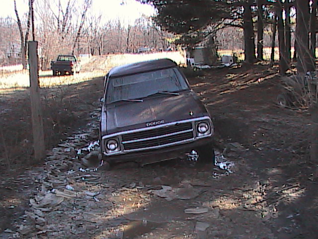 Brown Dodge Ramcharger stuck in mud, front view. Grille has horizontal bars. Headlights are round