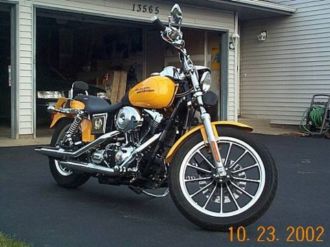 1998 Ford Crown Victoria - Yellow Harley-Davidson motorcycle parked in front of a garage with the door open.