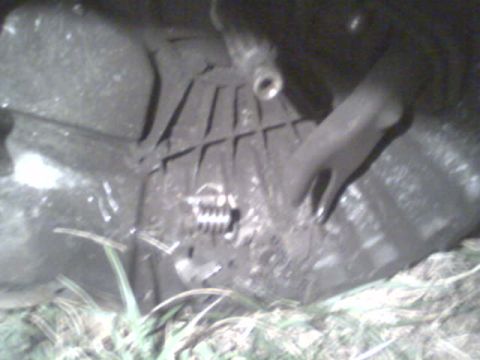 1985 Ford Bronco - Close-up of a vehicle's clutch and transmission housing, with a metal lever visible.