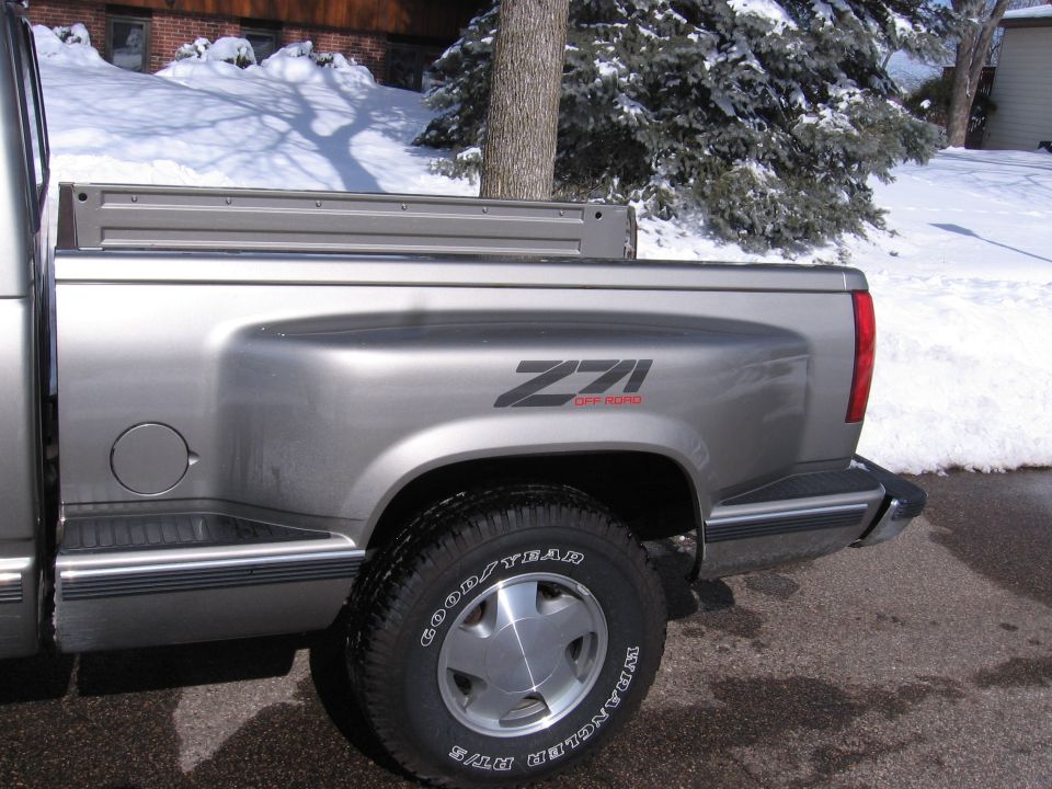 Silver Chevrolet Z71 pickup bed side in a snowy driveway