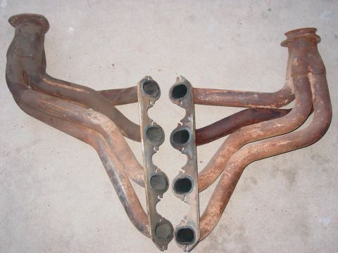1979 Ford Bronco - Rusty exhaust manifolds are shown on a concrete floor, with a website address visible in the lower right corner.