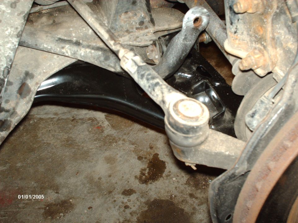 Car suspension parts, including a tie rod end and control arm, with visible rust and dirt. Date stamp reads 01/01/2005