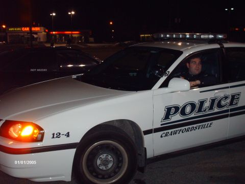 1995 Ford Probe - A police car with "CRAWFORDSVILLE" text on its side is parked at night, with another vehicle visible behind it.