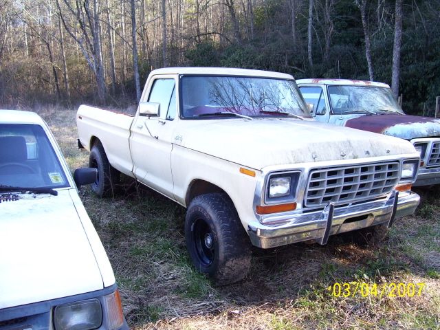 Tan vintage Ford pickup truck parked in a wooded field, dated 2007