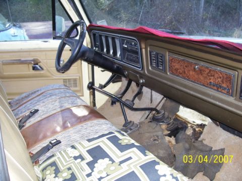1987 Toyota 4Runner - Interior of a 1970s Ford F-Series truck, a manual transmission and woodgrain dash trim.