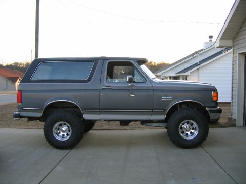 1989 Ford Bronco - Side profile of a lifted 1989 Ford Bronco with aftermarket wheels and tires.