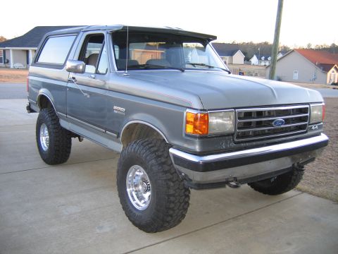 1989 Ford Bronco - This lifted Ford Bronco features a custom visor and large off-road tires.