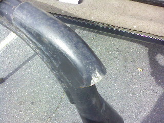 1995 Ford Bronco - Close-up of a damaged black plastic fender flare, showing wear and tear.