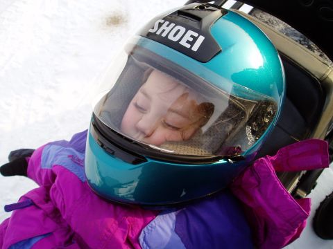 2000 Ford E350 - A child rests in the snow, wearing a teal SHOEI helmet with the visor up.