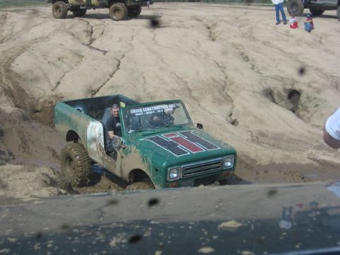 1989 Ford Bronco - An off-road vehicle navigates a muddy terrain, with visible text indicating it is 'UNDER CONSTRUCTION 4X4'.