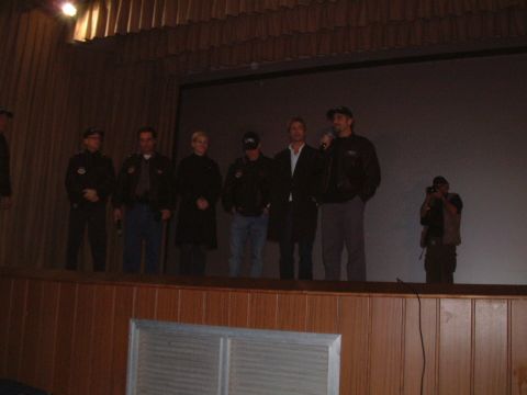1979 Ford Bronco - A group of people are on stage, possibly for a presentation, while a photographer captures the moment.