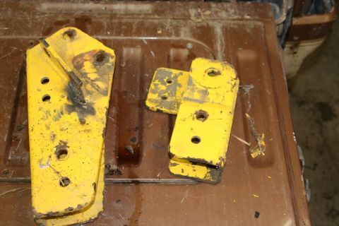 1989 Ford Bronco - Yellow lift kit components are shown on a brown surface, with the Supermotors.net logo in the lower right corner.