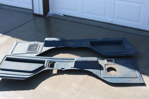 1989 Ford Bronco - Two blue plastic car door panels are laid out on a concrete surface in front of a garage door.