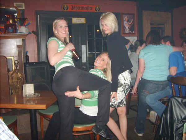 Three women and other people in a bar with a Jägermeister sign