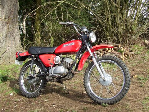 1997 BMW F650 - This red Kawasaki motorcycle features knobby tires, suitable for off-road use, and is shown in a natural outdoor setting.