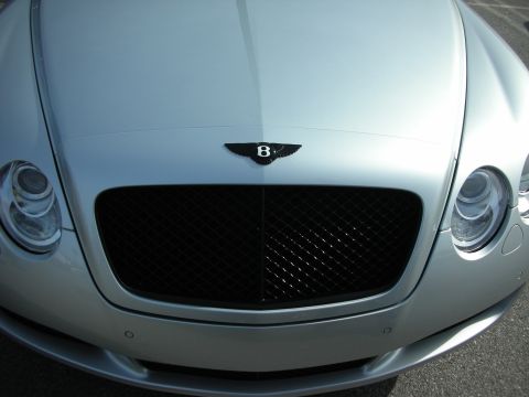 1998 Ford Crown Victoria - Close-up of the front of a silver Bentley Continental GT showing the mesh grille and winged 'B' hood emblem.