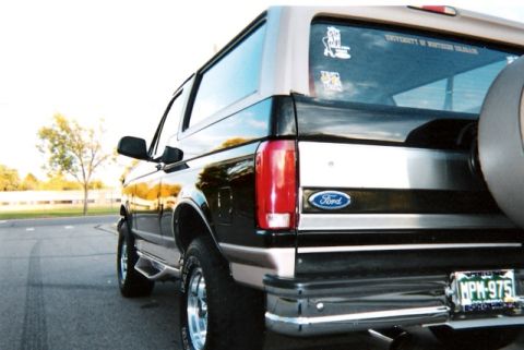 1996 Ford Bronco - Rear view of a 1996 Ford Bronco showing the quarter panel, spare tire, and university stickers.