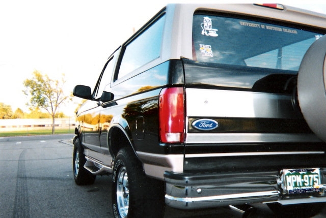 1996 Ford Bronco rear quarter panel, spare tire, and license plate MPH-975. University of Northern Colorado stickers on rear window