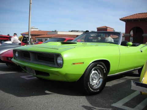 1998 Ford Crown Victoria - bright green Plymouth Barracuda convertible muscle car parked under blue skies at a strip-mall car show.
