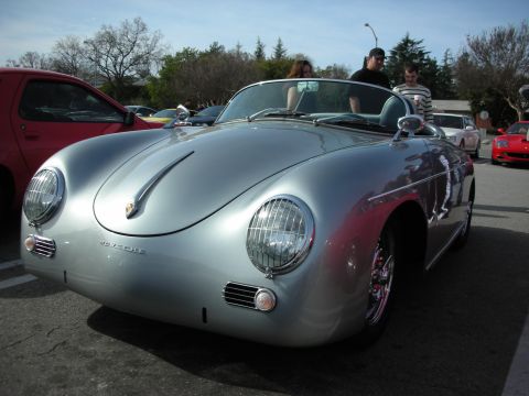 1998 Ford Crown Victoria - silver Porsche 356 Speedster convertible with chrome wheels parked at a sunny outdoor car show.