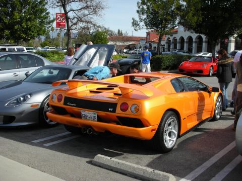 1998 Ford Crown Victoria - Rear three-quarter view of an orange Lamborghini Diablo VT parked at an outdoor car show.