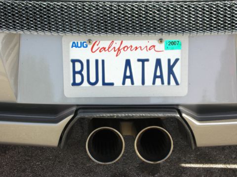 1998 Ford Crown Victoria - Rear of a silver sports car with a 2007 California 'BUL ATAK' license plate above twin polished exhaust tips.