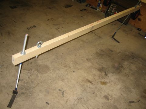 1996 Ford Bronco - A shop-built hardtop hoist spreader bar lying on a concrete garage floor: a length of 4x4 lumber fitted with galvanized threaded rods, hex…