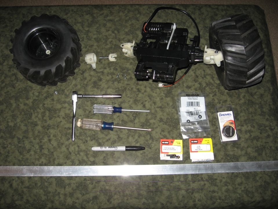 RC car axle, differential, and tires with tools and parts