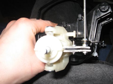 1990 Ford Bronco - Close-up of a white plastic HVAC actuator mechanism with attached metal components.