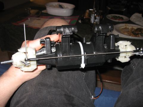 1990 Ford Bronco - A person holds a black plastic automotive part with white components and wiring.