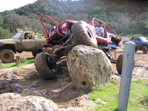 1989 Ford Bronco - An off-road buggy navigates a challenging rocky and muddy terrain, with other vehicles present in the scene.