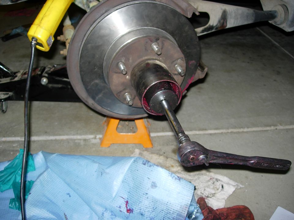 Tightening wheel bearings.  Inner nut installed and tightened first to 50lbs, then backed off & retightened to 40lbs.  Washer  inside tab installed in axel groove, & hole in washer installed on inner nut pin.   Outboard nut tightened to 200lbs.