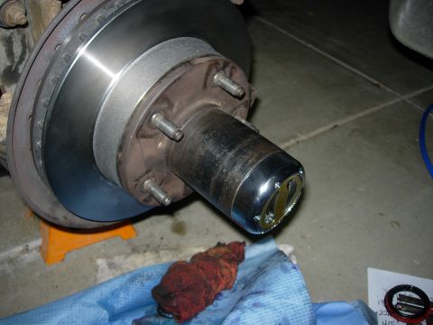 1990 Ford Bronco - Close-up of a vehicle's brake rotor and hub assembly, with a chrome cap on the hub.