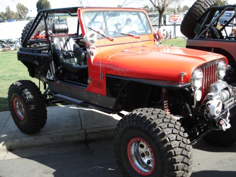 1994 Ford Bronco - This heavily modified Jeep features oversized tires, a roll cage, and a winch, suggesting it's built for extreme off-roading.