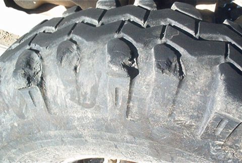 1986 Ford Bronco - Close-up of a worn tire tread, showing damage to the lugs.