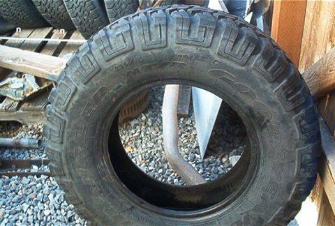 1986 Ford Bronco - A close-up view of a tire, showing its tread and sidewall markings.