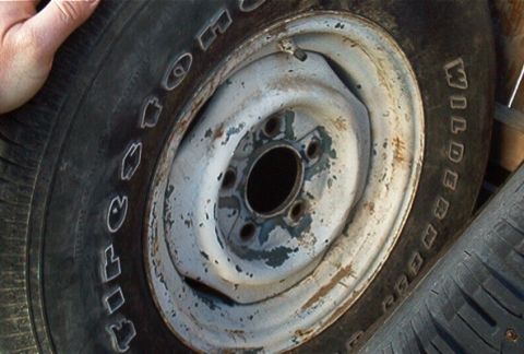 1986 Ford Bronco - A close-up shows a tire with white lettering and a worn white steel wheel, likely from an older vehicle.