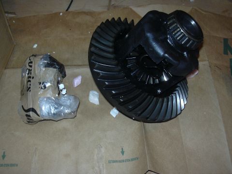 1996 Ford Crown Victoria - A differential gear set and a packaged component are shown on a cardboard surface.
