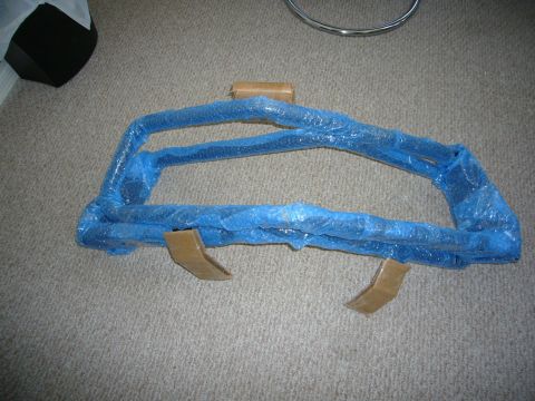 2000 Ford Crown Victoria - A new bull bar, still in its protective packaging, rests on a carpeted floor.