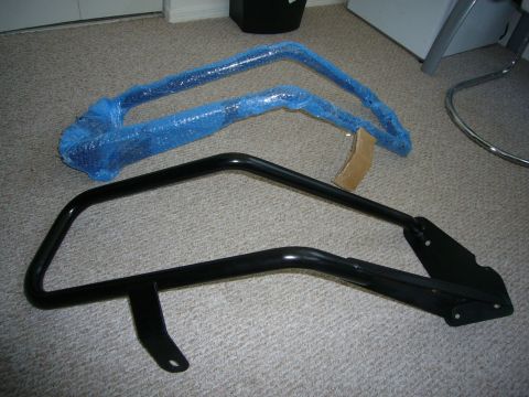 2000 Ford Crown Victoria - Two metal bars, one wrapped in blue bubble wrap, are shown on a carpeted floor.