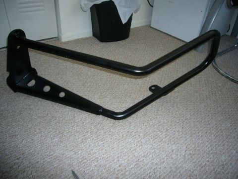 2000 Ford Crown Victoria - A black metal bull bar is shown lying on a carpeted floor.