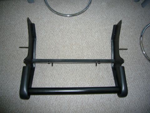 2000 Ford Crown Victoria - A black bull bar is shown lying on a carpeted surface, with chrome rings visible in the background.